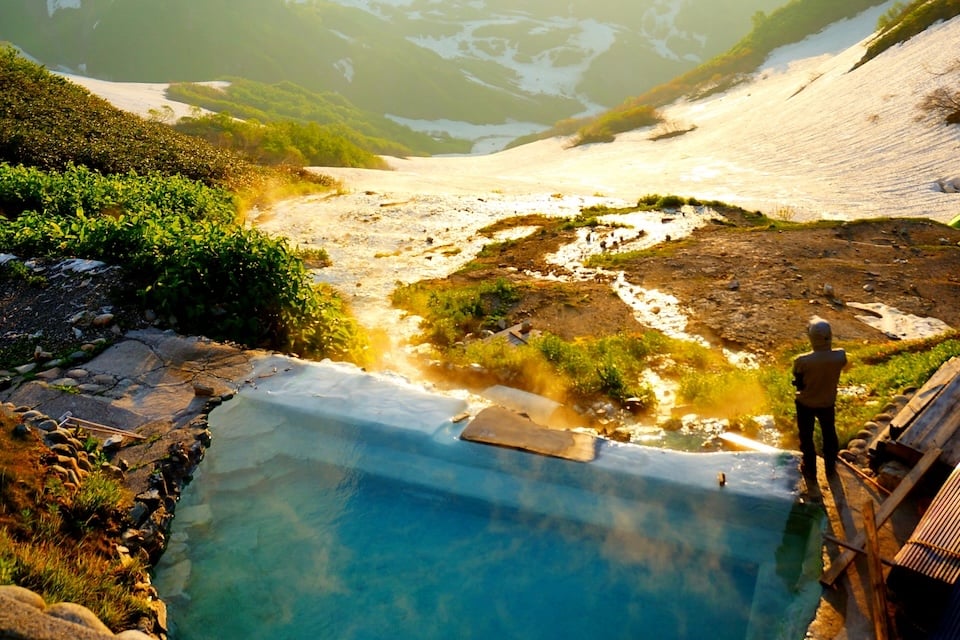 白馬鑓温泉の温泉と夕日を眺める人