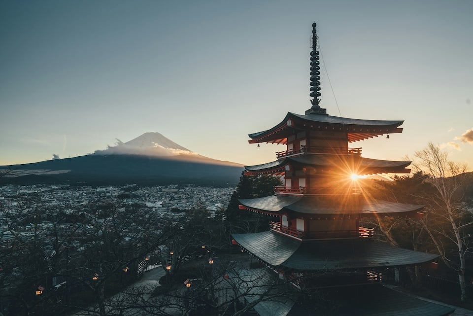 A serene view of a traditional Japanese pagoda with Mount Fuji in the background, representing refined luxury travel experiences in Japan.